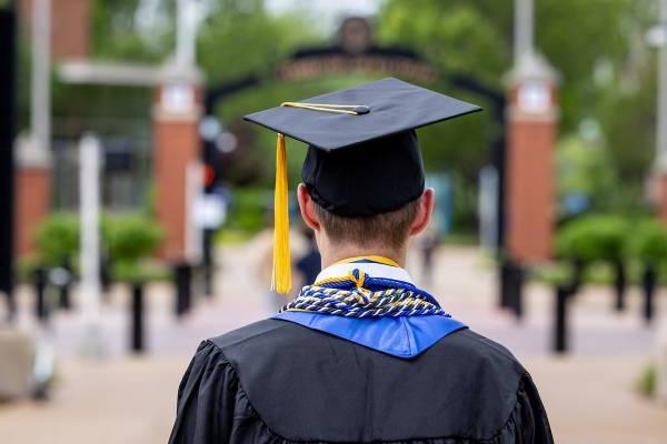 View from back of graduate dressed in gown and mortarboard